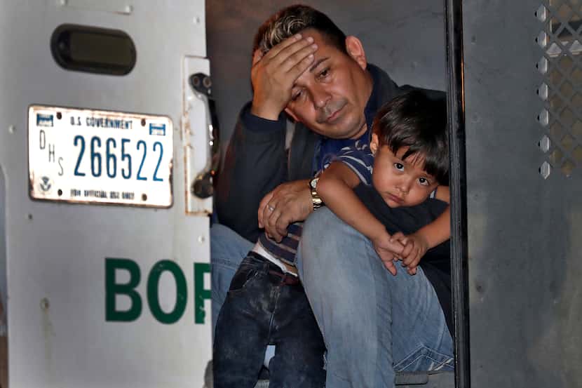 Un padre y su hijo de 3 años se asoman a la puerta de un vehículo de la Patrulla Fronteriza...