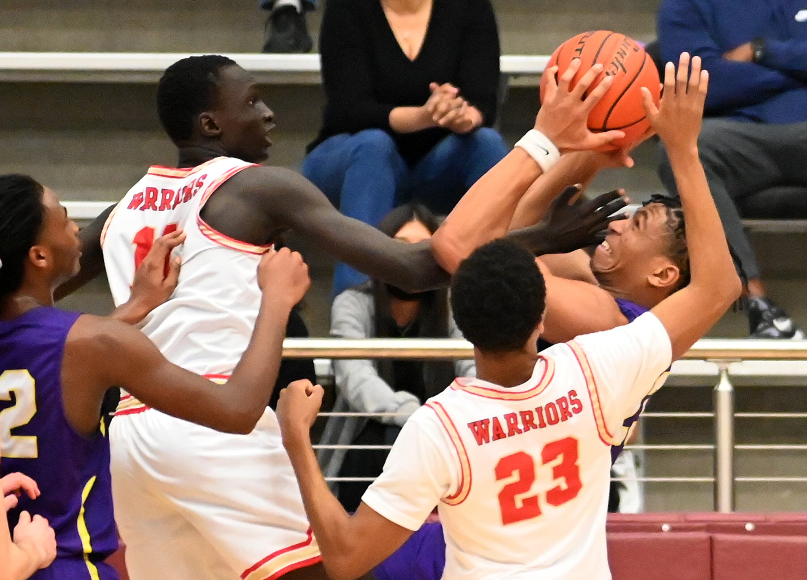 Richardson’s Derek Burns has his shot contested by South Grand Prarrie’s Ring Deng and Jevon...