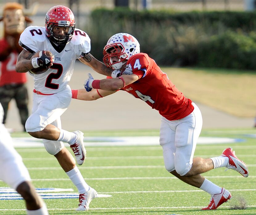 Cedar Hill's Laquvionte Gonzalez (2) stiff arms Waco Midway's Keith Efferson during the...