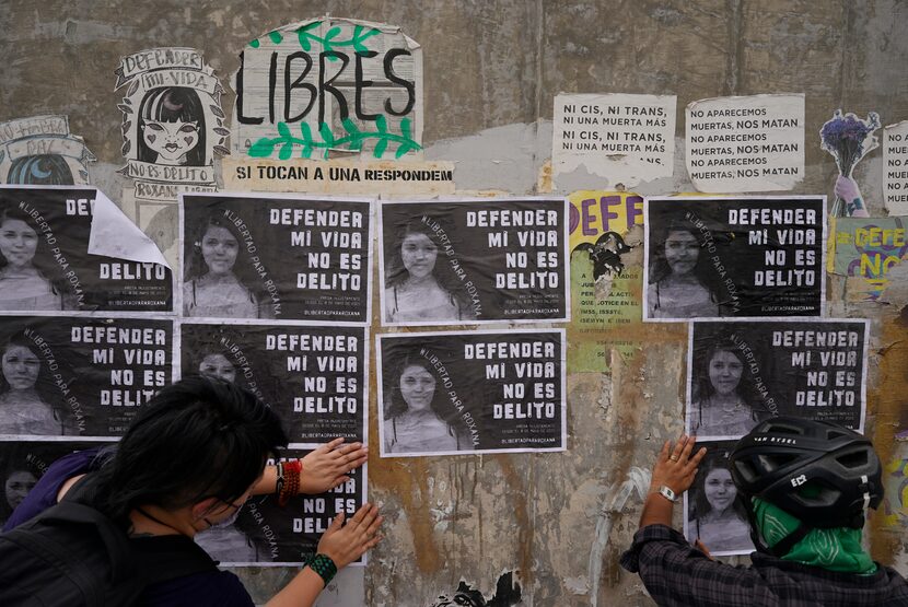 Activistas pegan volantes con la fotografía de Roxana Ruiz con la frase "Defender mi vida no...