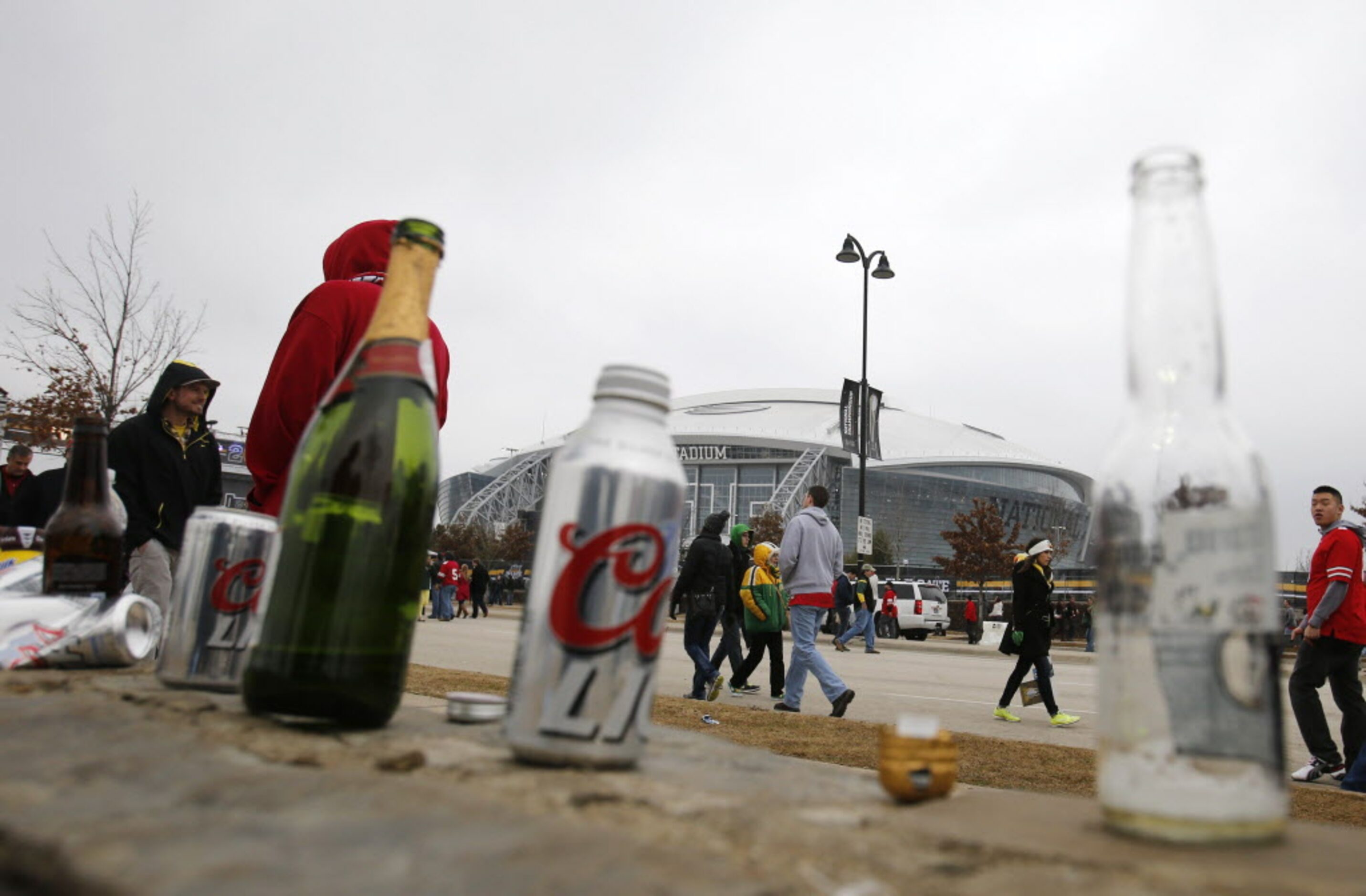 Empty beer and alcoholic drinks line a curb outside the stadium before a game between Oregon...