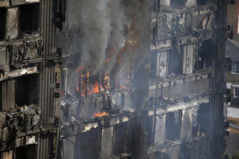 Partes de un edificio siguen quemándose horas después de un gran incendio en unos...