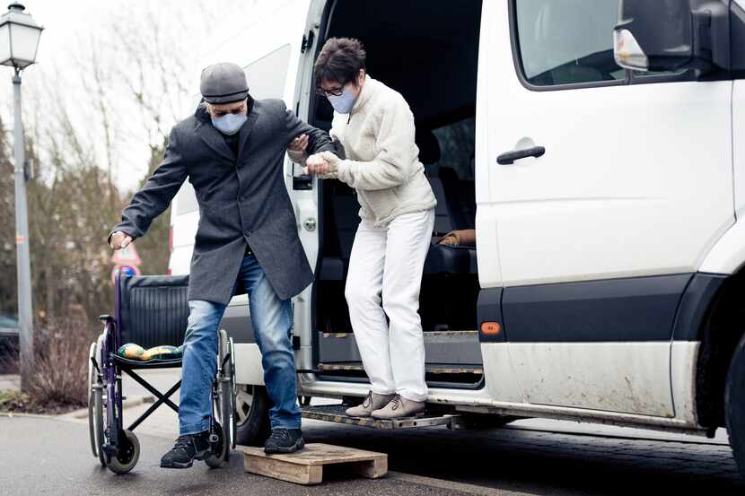 Man helping woman out of a white van