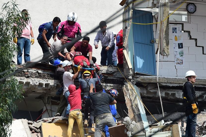 A woman is pulled out of the rubble alive following a quake in Mexico City on Tuesday. 