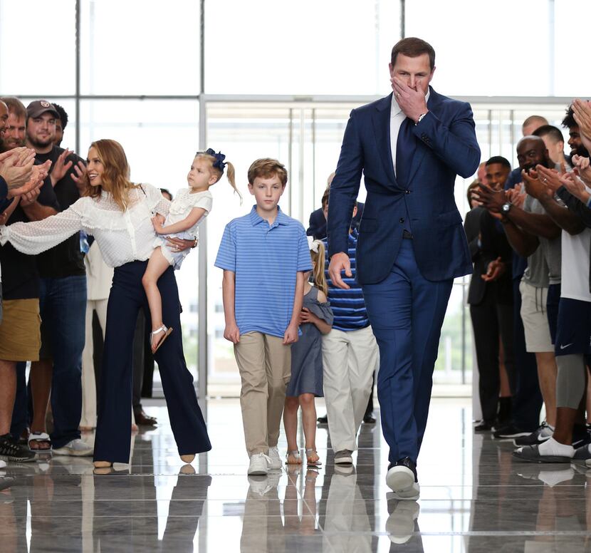 Dallas Cowboys tight end Jason Witten is greeted by players and coaches walking into a news...