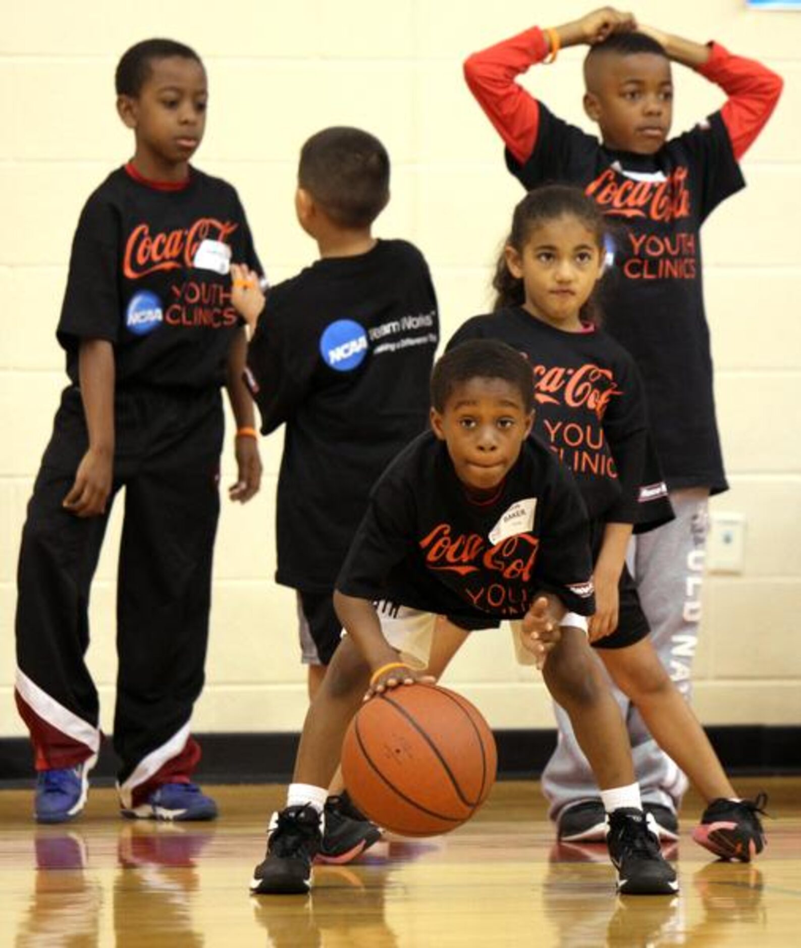 
Javon Baker,8, of DeSoto dribbles the basketball as he waits with other youngsters in his...