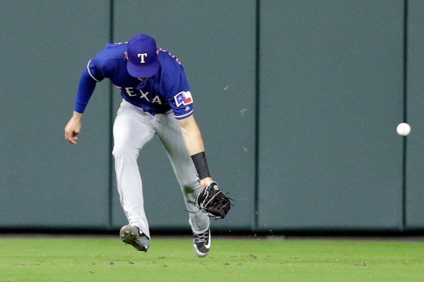 Texas Rangers center fielder Drew Robinson tries to field a hit by Houston Astros' Marwin...