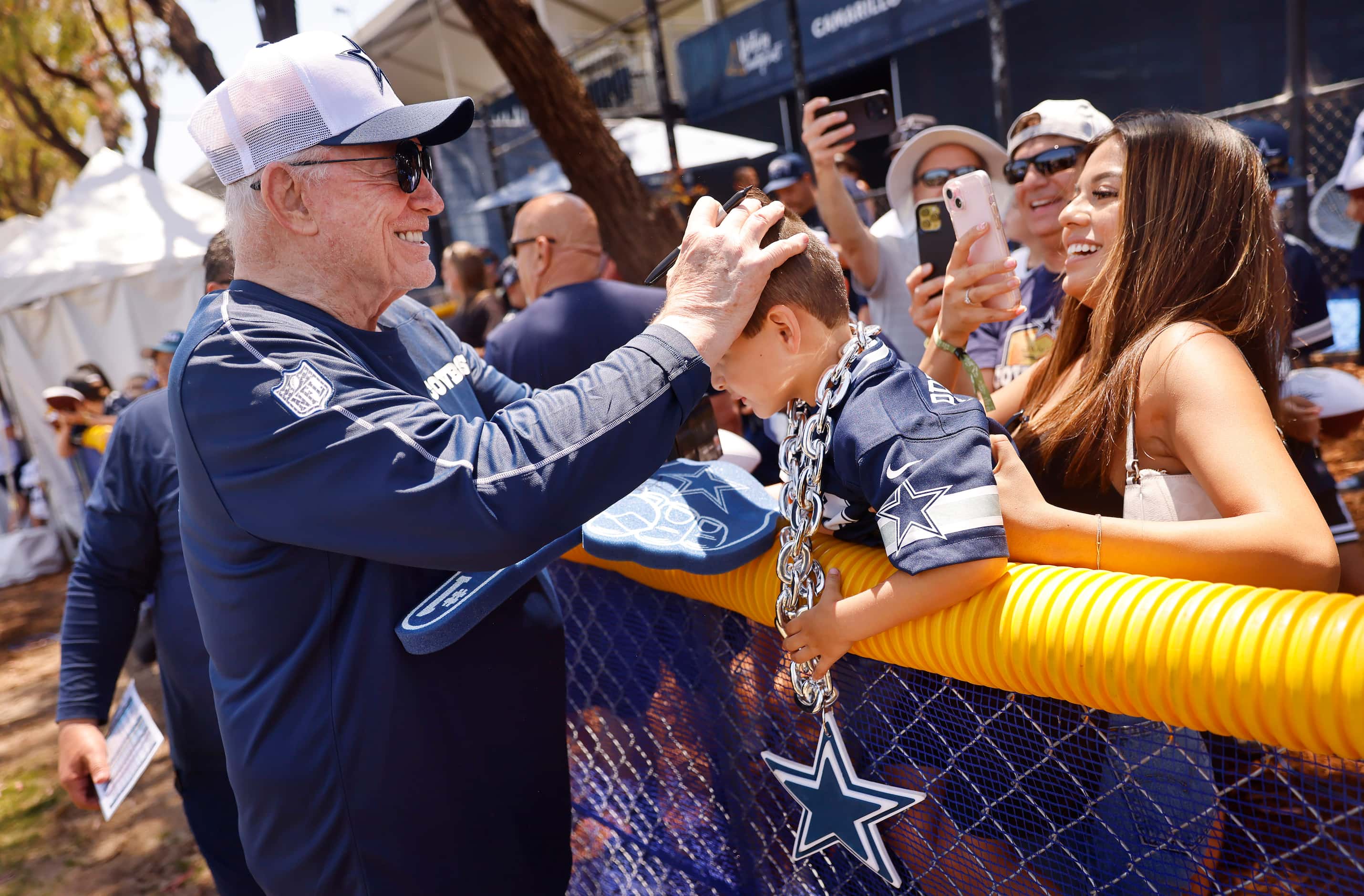 Dallas Cowboys owner Jerry Jones rubs young Matthew Hernandez’s head after singing an...