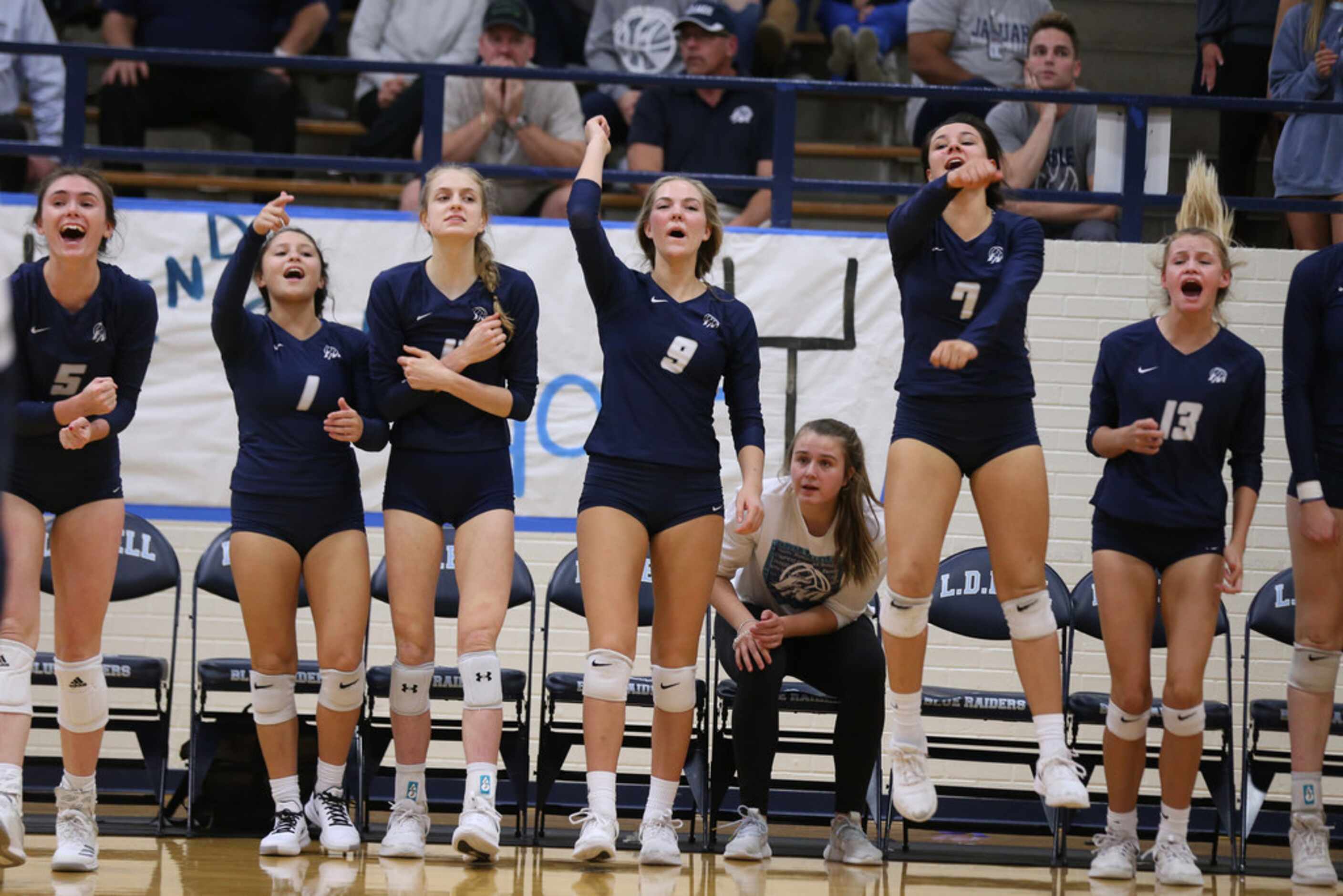 Flower Mound volleyball players cheer during the final moments of a high school volleyball...