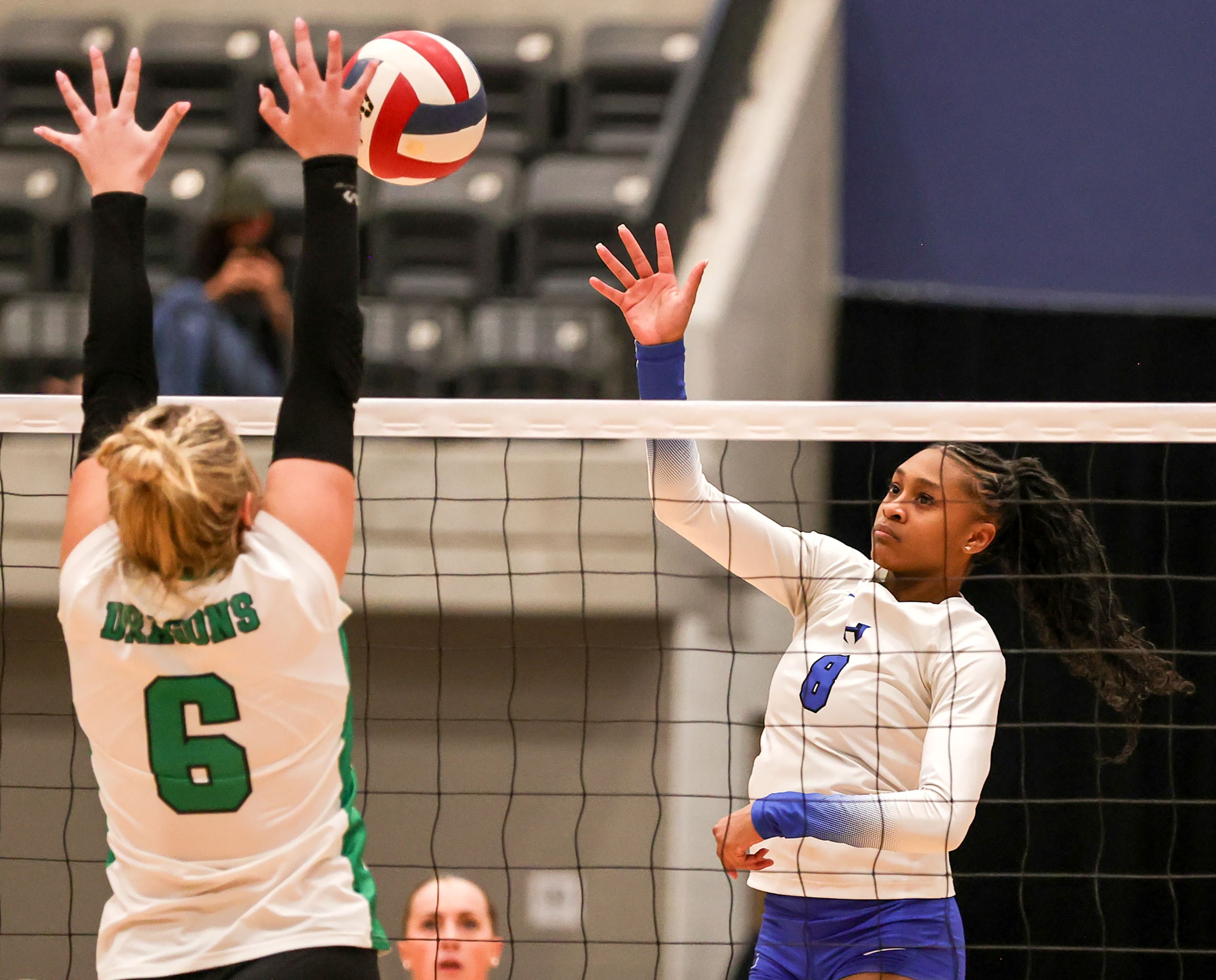 Hebron's Taylor Johnson (8) tries to get a kill past Southlake Carroll's Mary Beth Morse (6)...