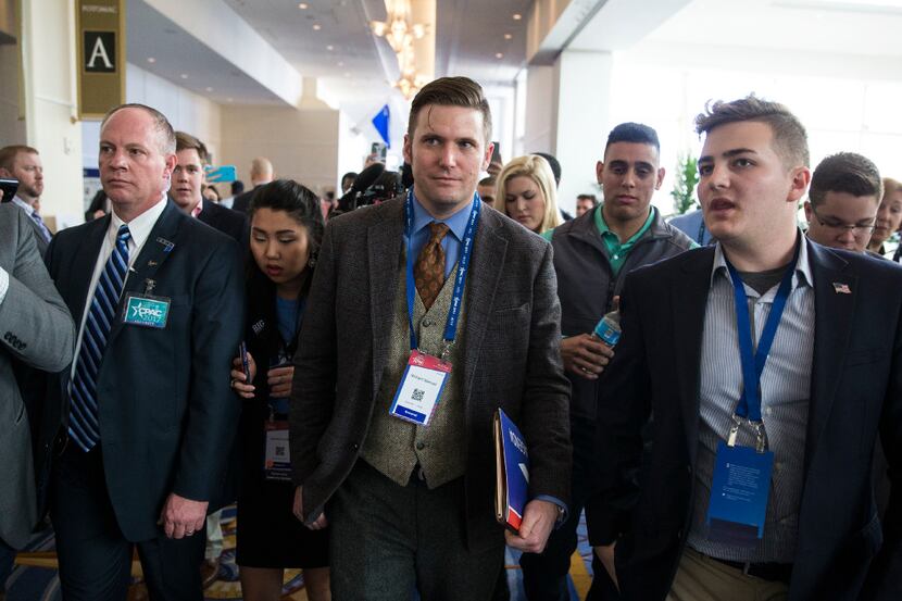 Richard Spencer, center, a leading white supremacist, speaks with reporters before being...