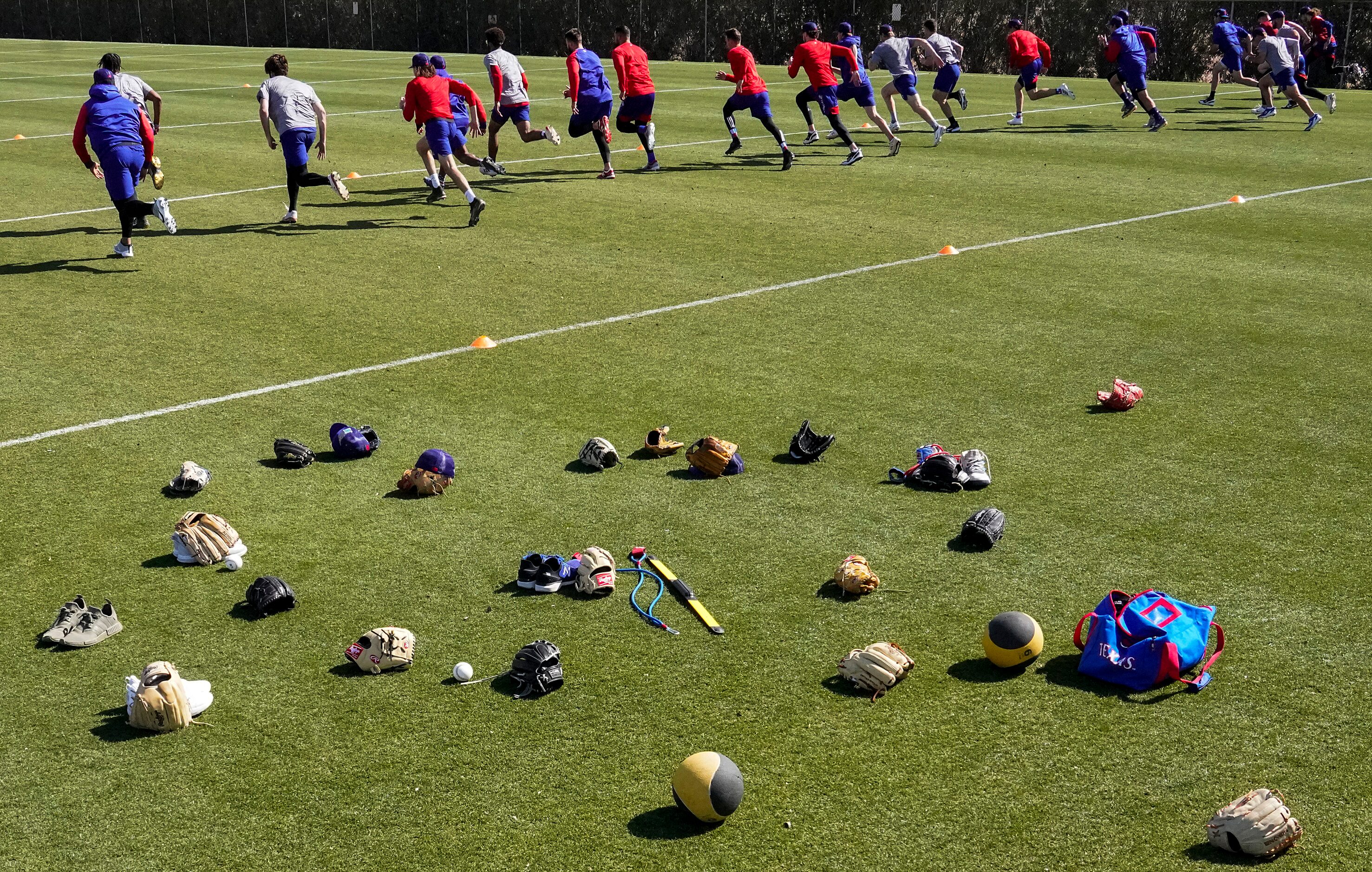 Texas Rangers minor leaguers run on a conditioning field during the team’s first minor...