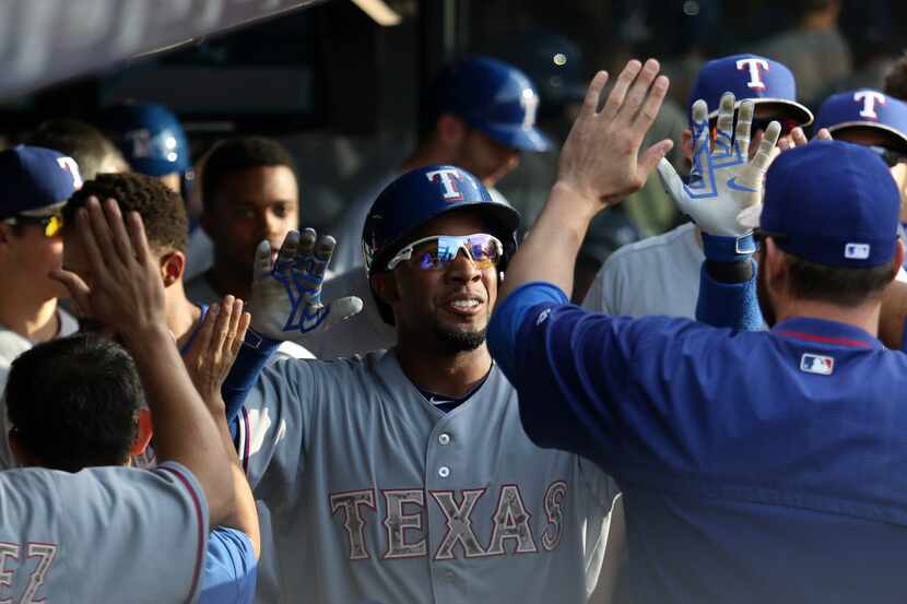 Texas Rangers Elvis Andrus high-fives teammates in the dug out after hitting a solo home run...