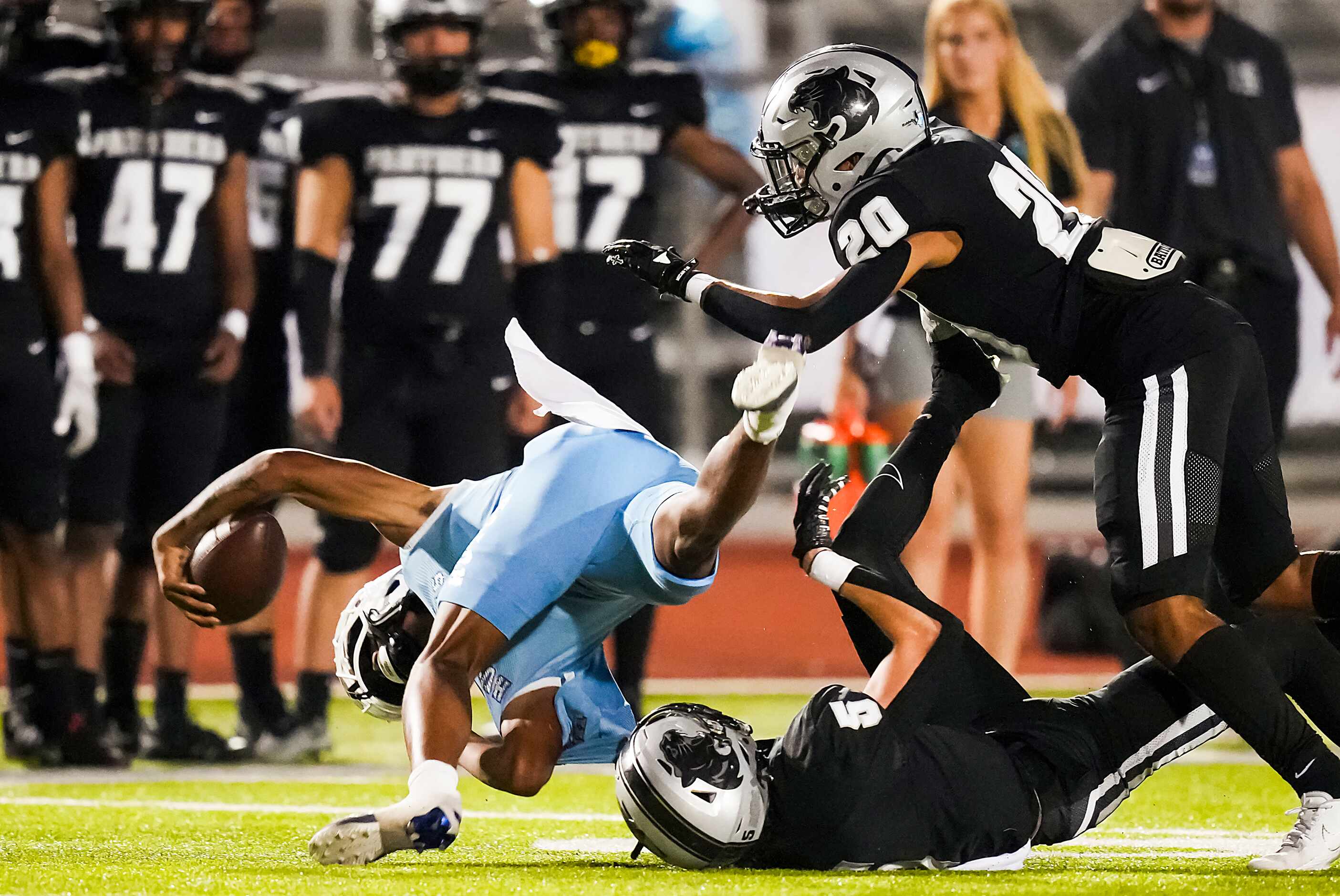 Wilmer-Hutchins quarterback Tamajae Mcmillon (9) is tripped up by Panther Creek   linebacker...