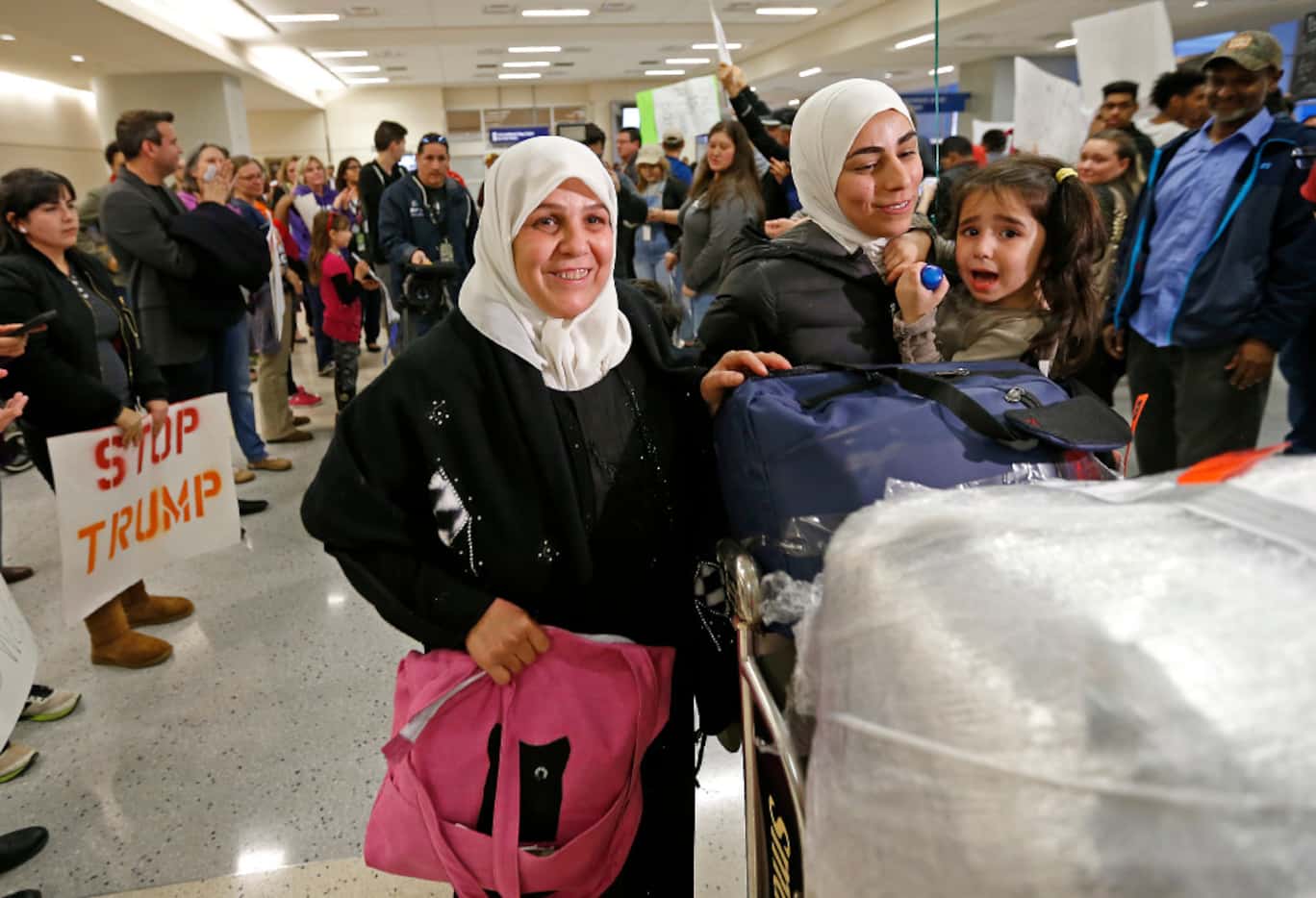 Najah Alshamieh (left), from Syria, leaves Terminal D with her daughter Miriam Yasin....
