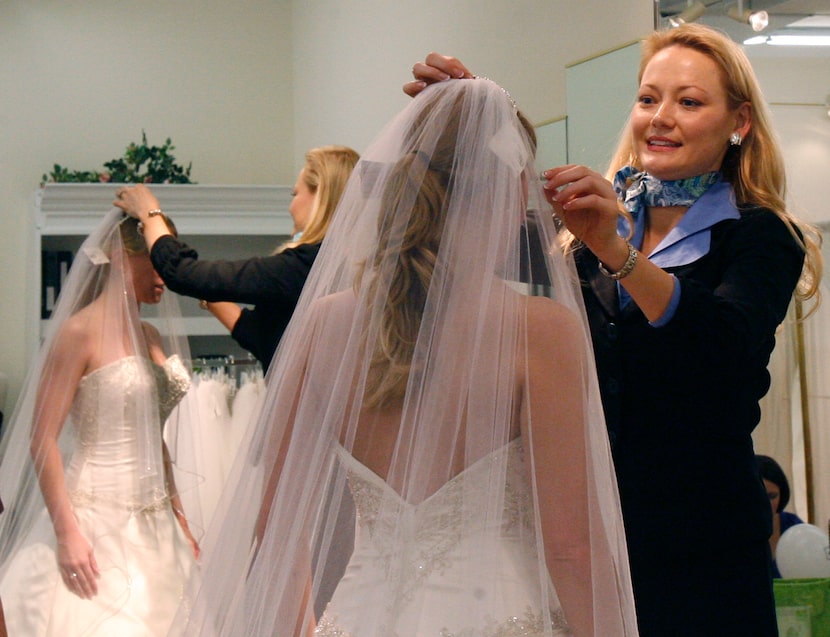 Terry Costa chief executive officer Tina Loyd assists Amanda Hill as she selects a wedding...