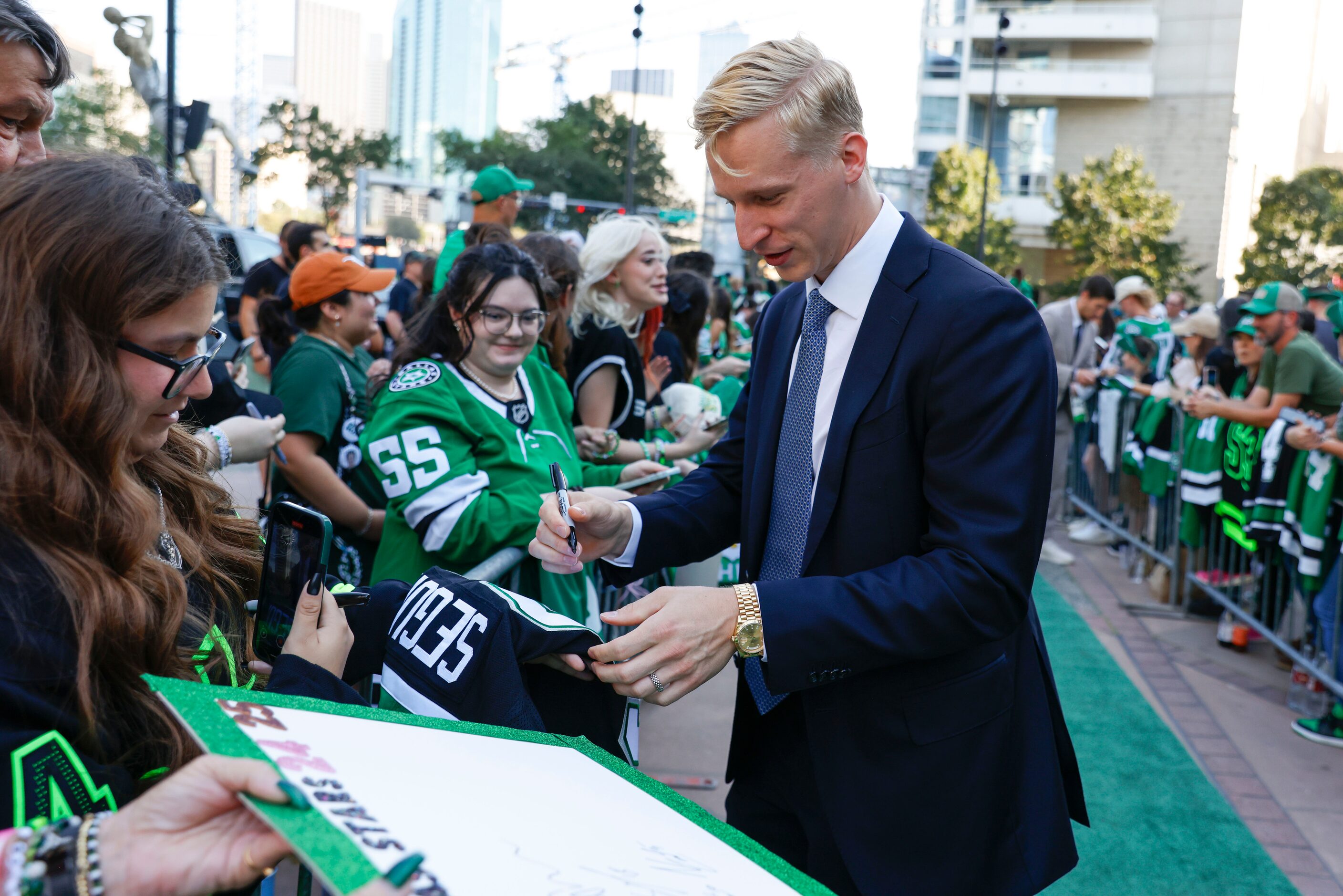 Dallas Stars defenseman Esa Lindell gives autographs to fans as he makes his way during the...