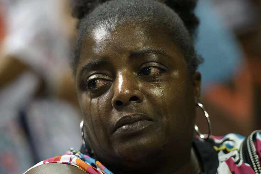 Barbara Lloyd listens to "We Shall Overcome" during a vigil at TD Arena for victims of the...