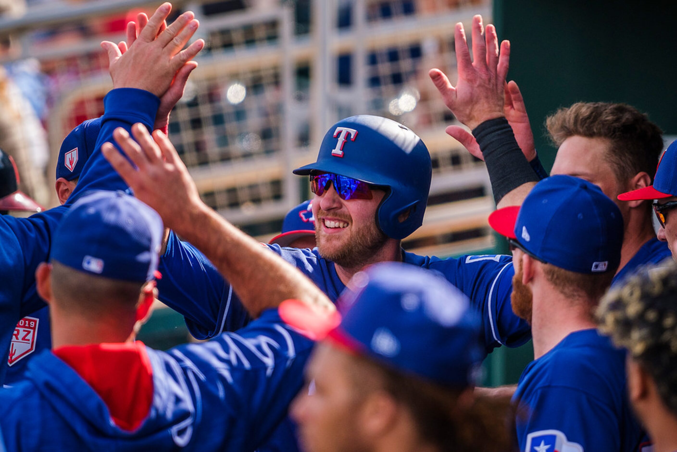 Texas Rangers catcher Jett Bandy celebrates with teammates as he reaches the dugout afgter...