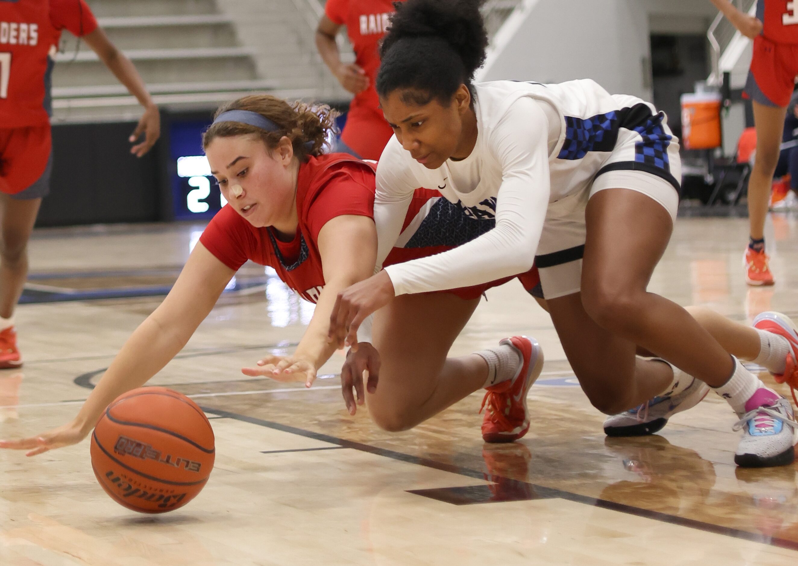 Denton Ryan forward Aspen Hicks (21), left, dives for the ball as well as Hebron guard Paris...