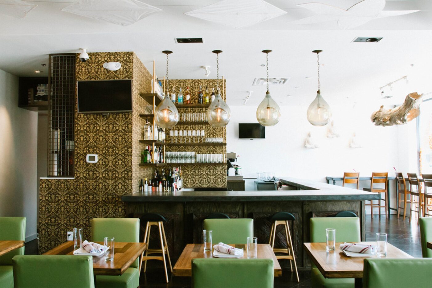 A rich black and gold damask-patterned wall welcomes guests to Pakpao's bar.