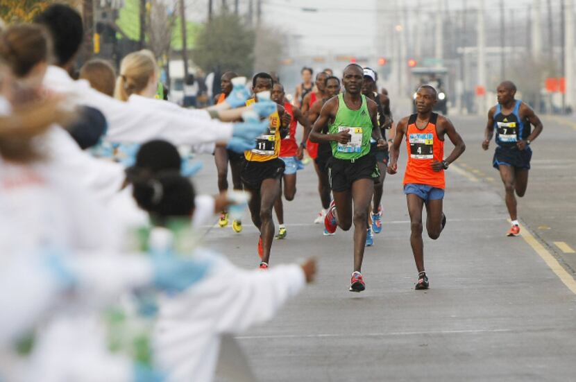 A pack of lead runners approach a water station near the third mile marker on Singleton...