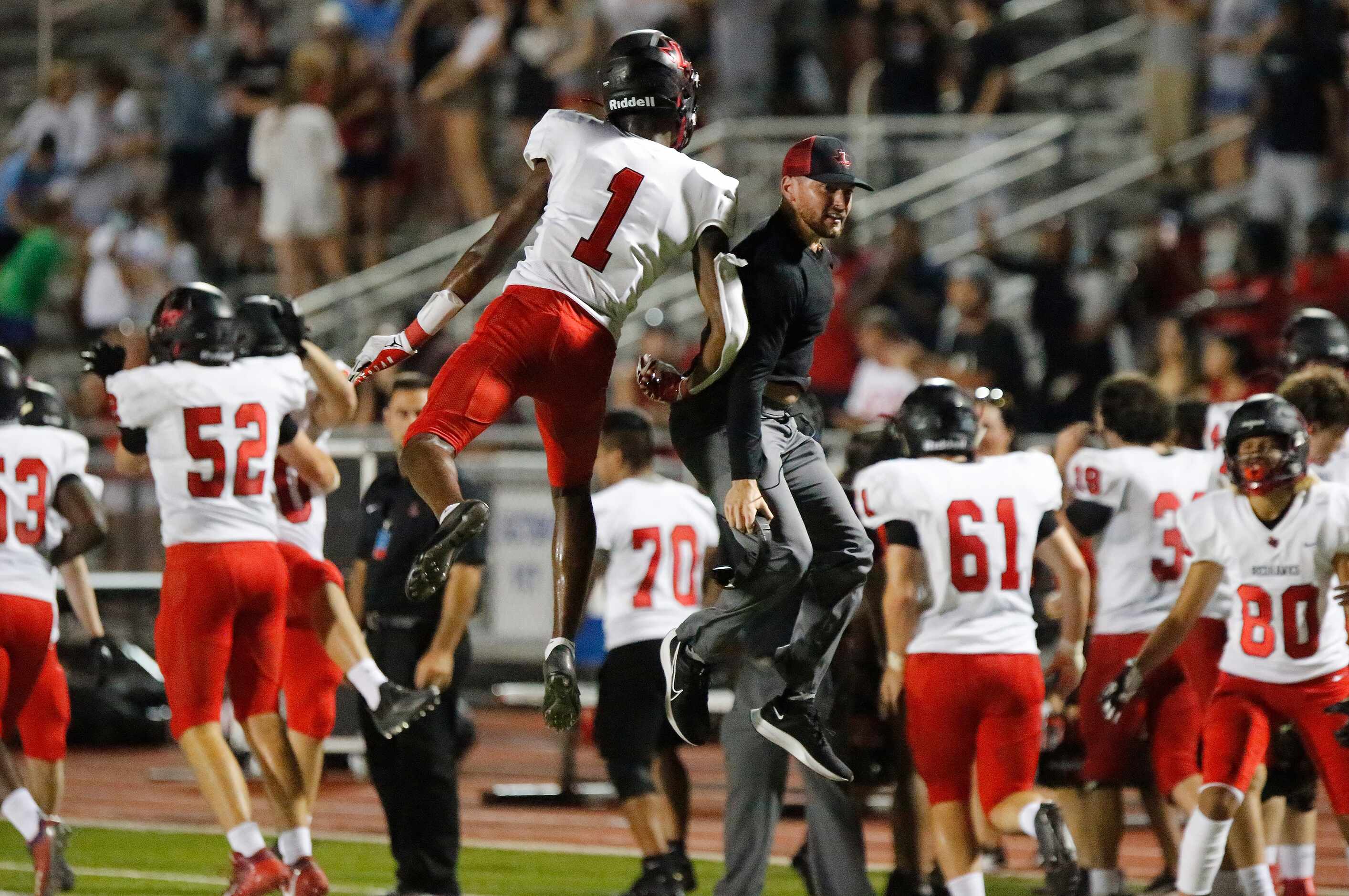 Liberty High School wide receiver Kamryn Smith (1) leaps to congratulate a coach after...