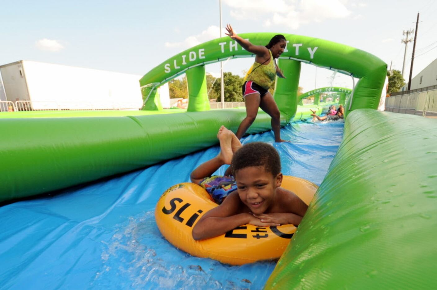 A participant slides on a tube at Slide In the City in Dallas, TX on August 22, 2015....