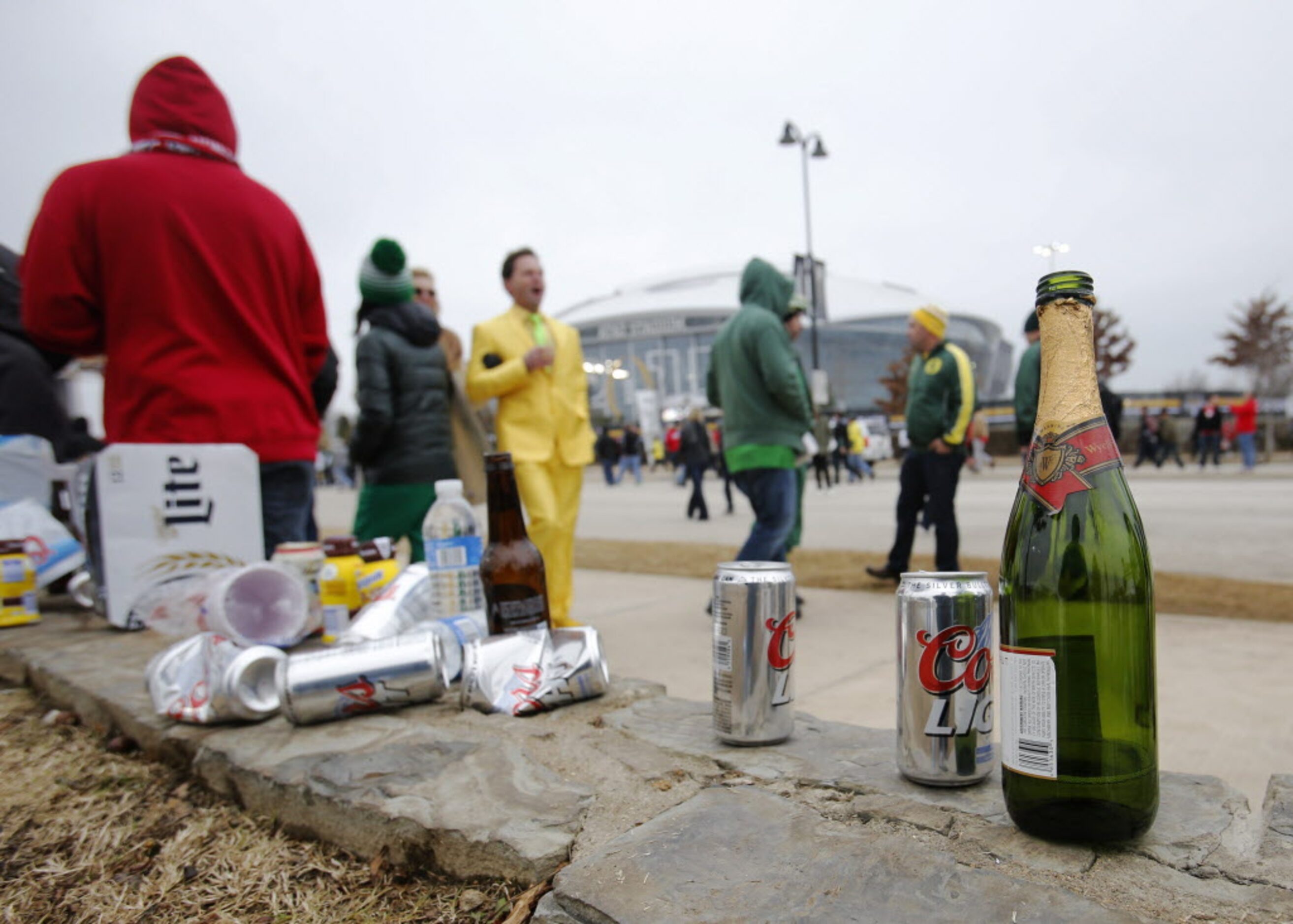 Empty beer and alcoholic drinks line a curb outside the stadium before a game between Oregon...