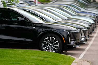 Vehicles sit in a row outside a dealership, June 2, 2024, in Lone Tree, Colo. Car...