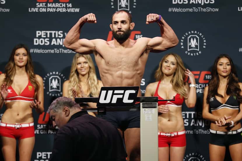 Johny Hendricks, of Dallas, flexes while being weighed during the weigh-ins for UFC 185 at...