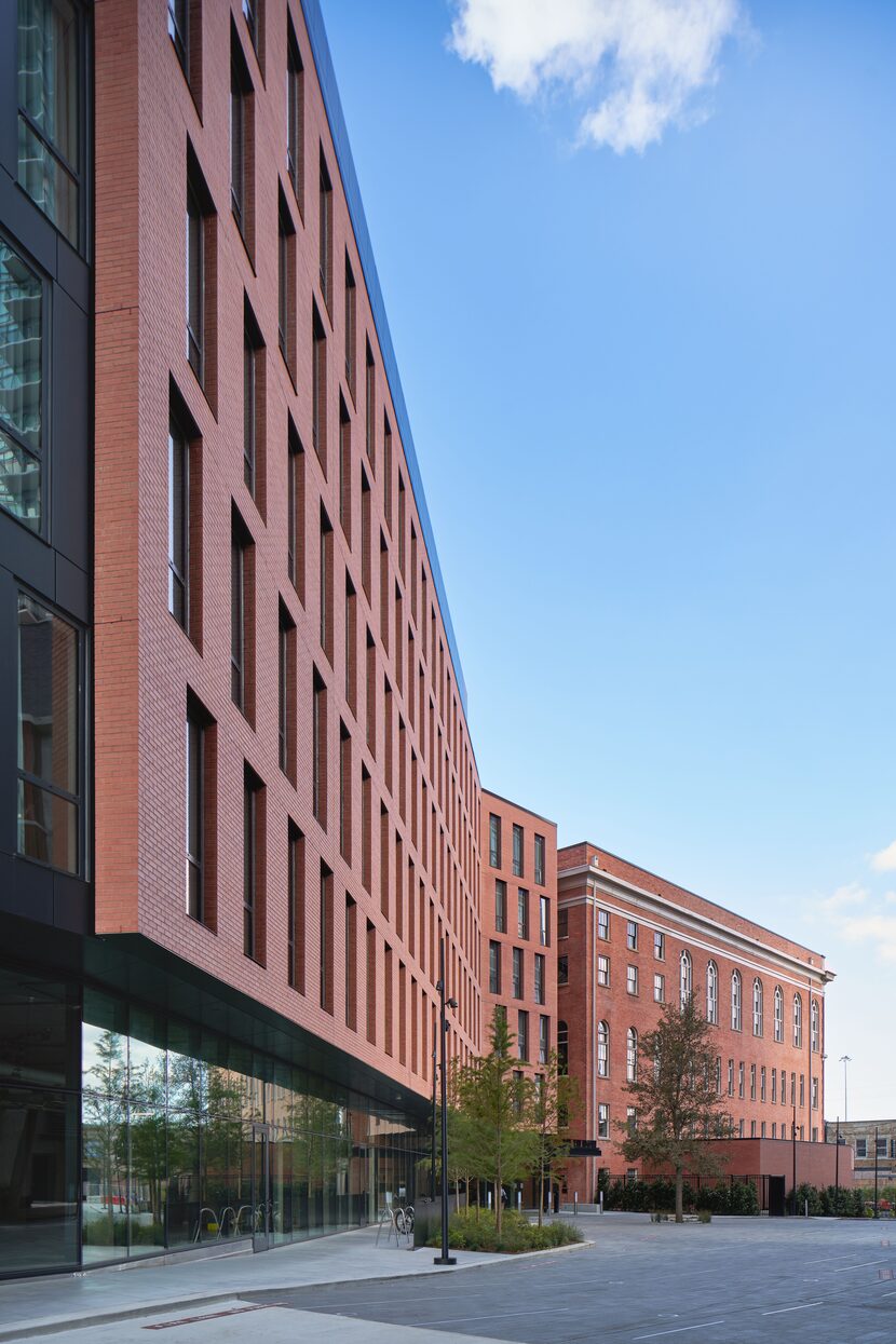 A view juxtaposing part of the facade of a new building (left) with the historic building...