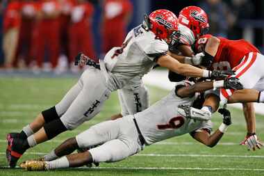 Cedar Hill's Richard Moore (4) and Darrell Miller (9) force a fumble from Katy running back...