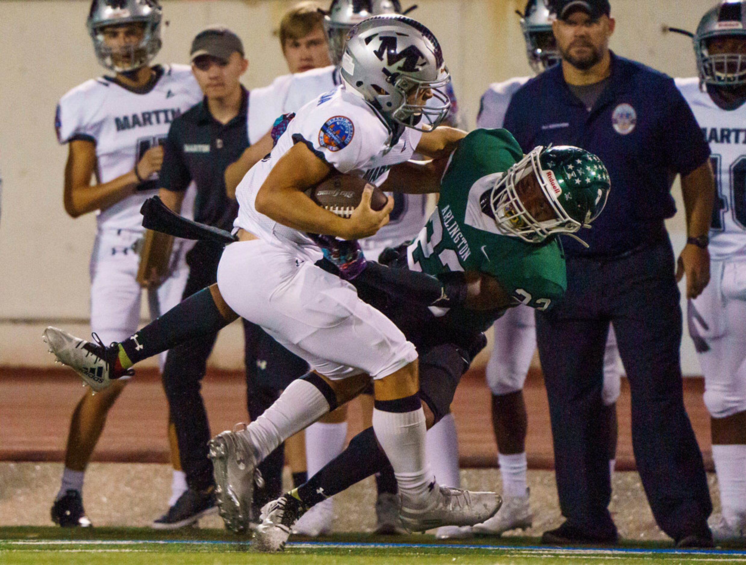 Arlington Martin quarterback Zach Mundell (6) is brought down by Arlington defensive back...