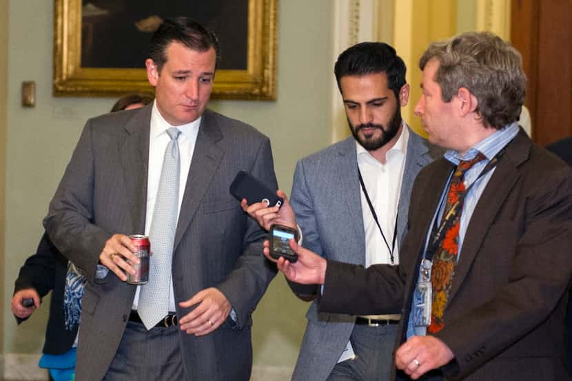 Sen. Ted Cruz speaks with reporters as he walks to the Senate Chamber for a special session...
