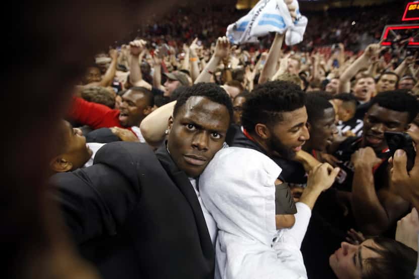 Texas Tech's Norense Odiase, left, who is injured and in street clothes, celebrates with his...