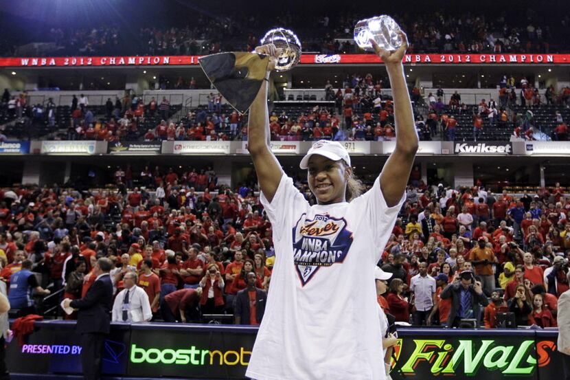 Indiana Fever forward Tamika Catchings celebrates with the trophy and the MVP award after...