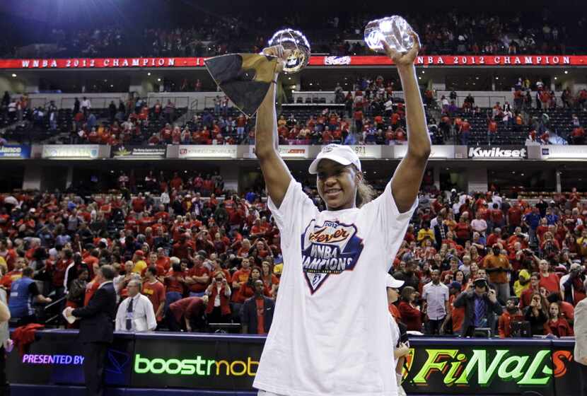 Indiana Fever forward Tamika Catchings celebrates with the trophy and the MVP award after...