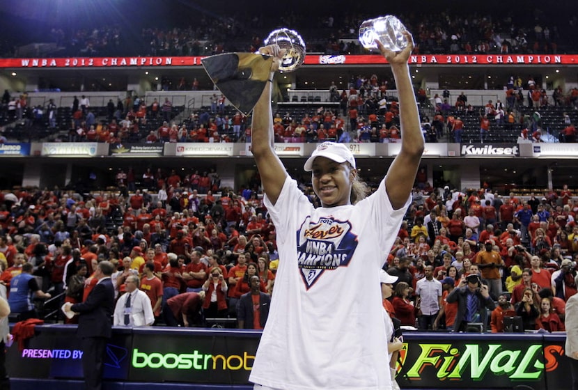 Indiana Fever forward Tamika Catchings celebrates with the trophy and the MVP award after...