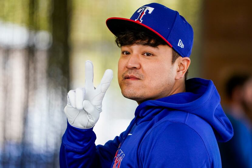 Texas Rangers outfielder Shin-Soo Choo motions to a teammate as he waits his turn in the...