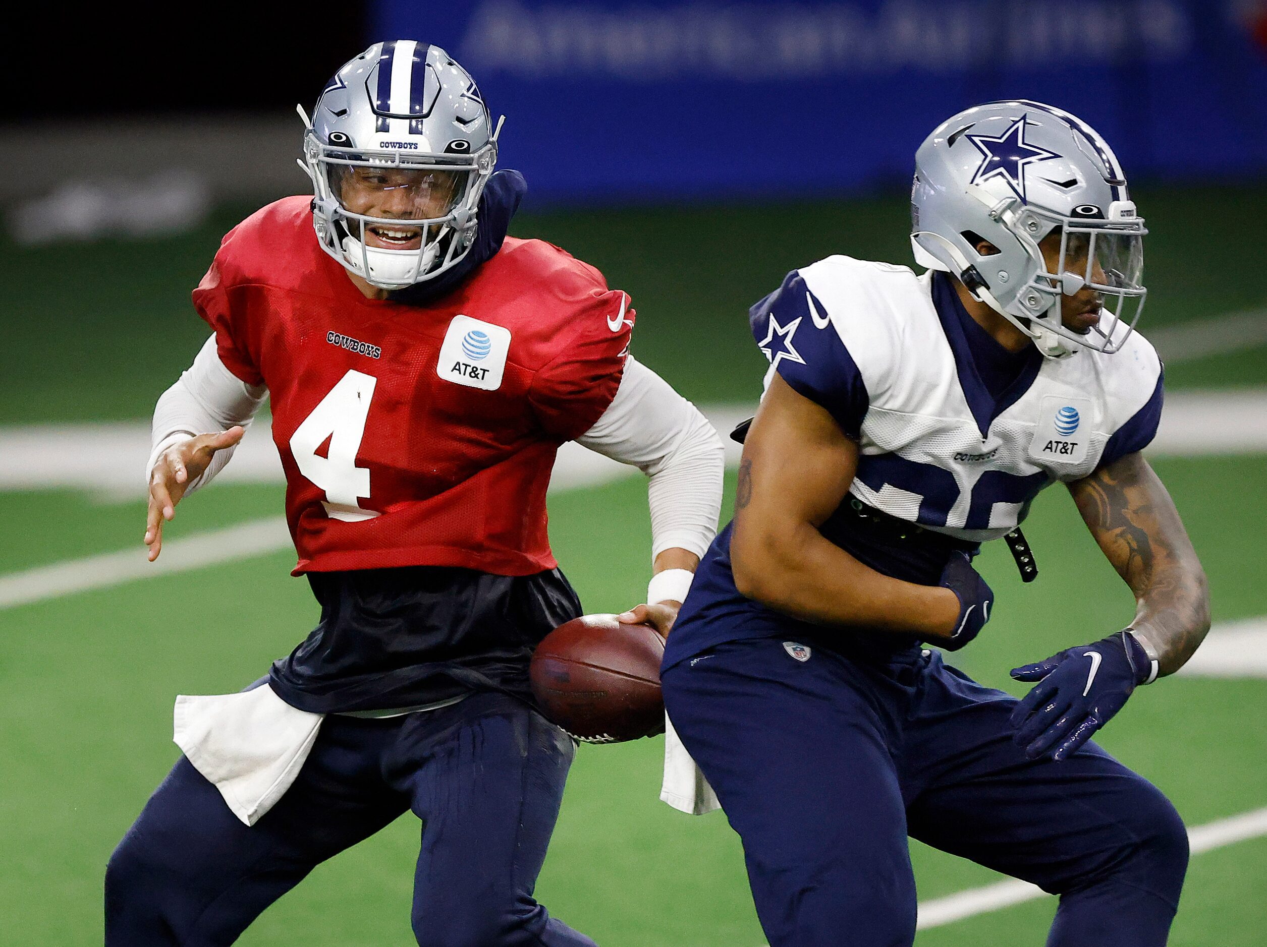 Dallas Cowboys quarterback Dak Prescott (4) fakes the handoff to running back Tony Pollard...