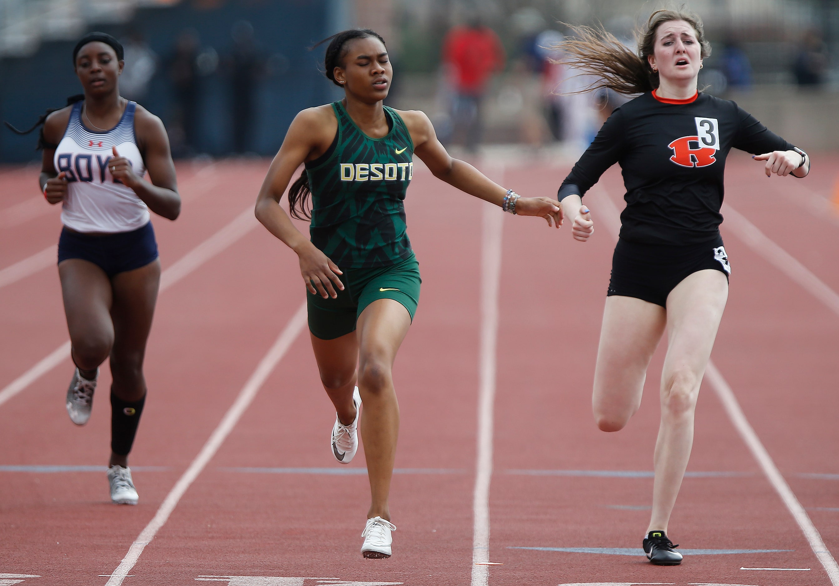 Amelliah Bireow (center), finished first in her heat for DeSotto High School during the...