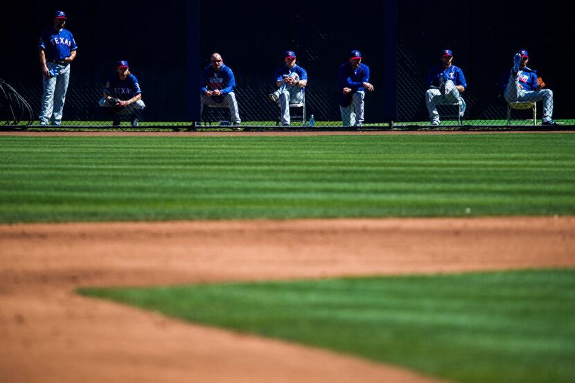 Texas Rangers watch the second inning of a spring training game against the Seattle Mariners...