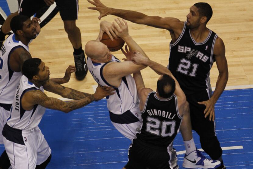 Dallas Mavericks Chris Kaman fights for the ball with San Antonio Spurs' Tim Duncan and Manu...