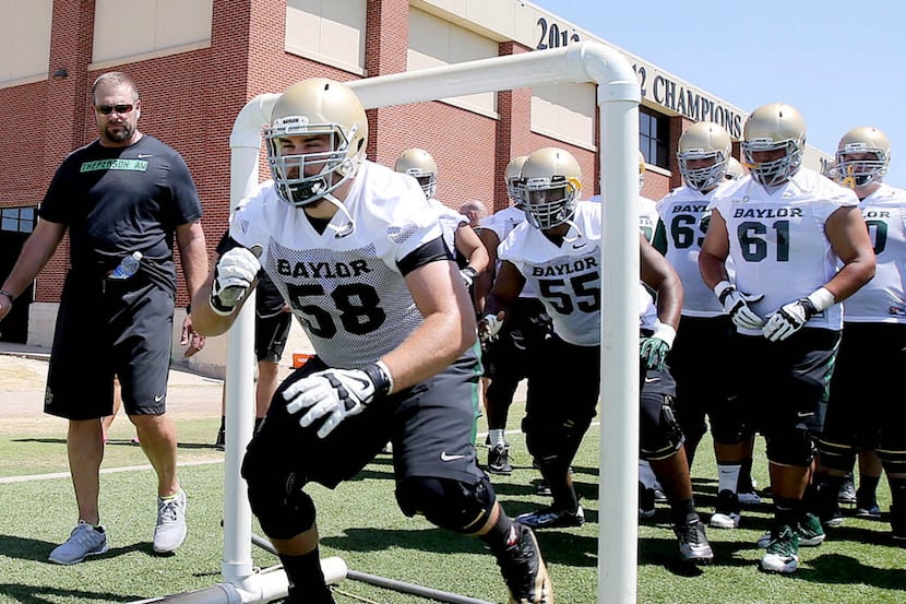 Baylor's Spencer Drango runs through a drill with the rest of the offensive line during the...