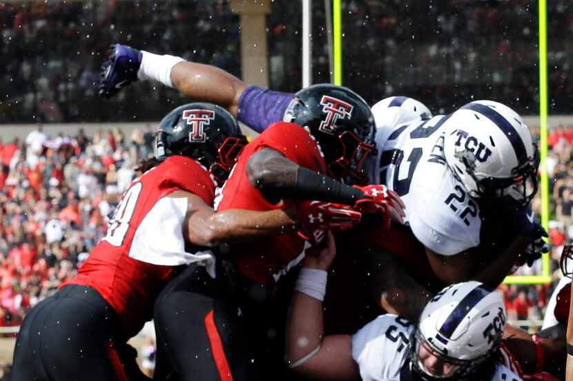 TCU running back Aaron Green (22) goes over the line with teammate center Joey Hunt (55) and...