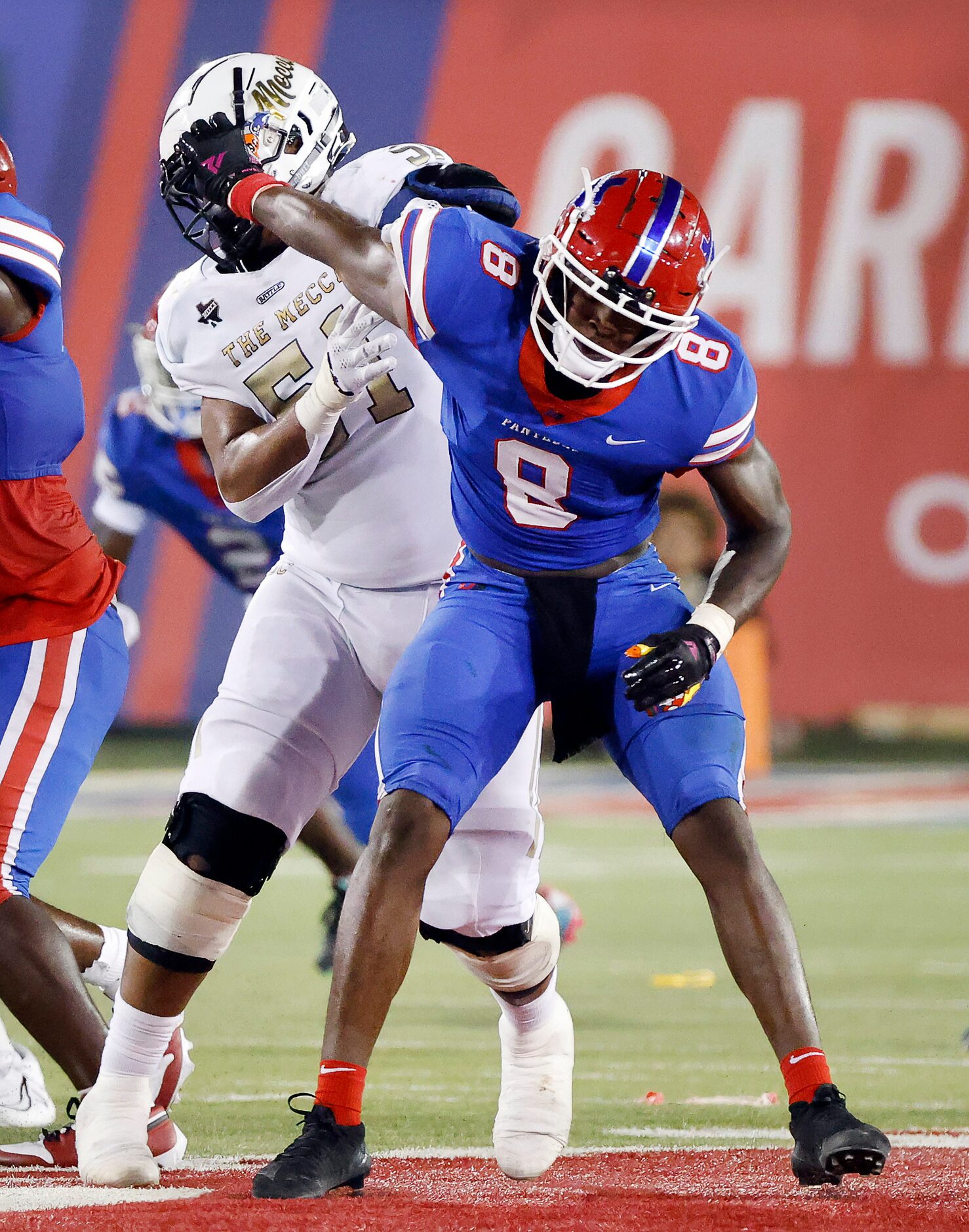 Duncanville defensive end Colin Simmons (8) gives a stiff arm to South Oak Cliff’s Jaden...