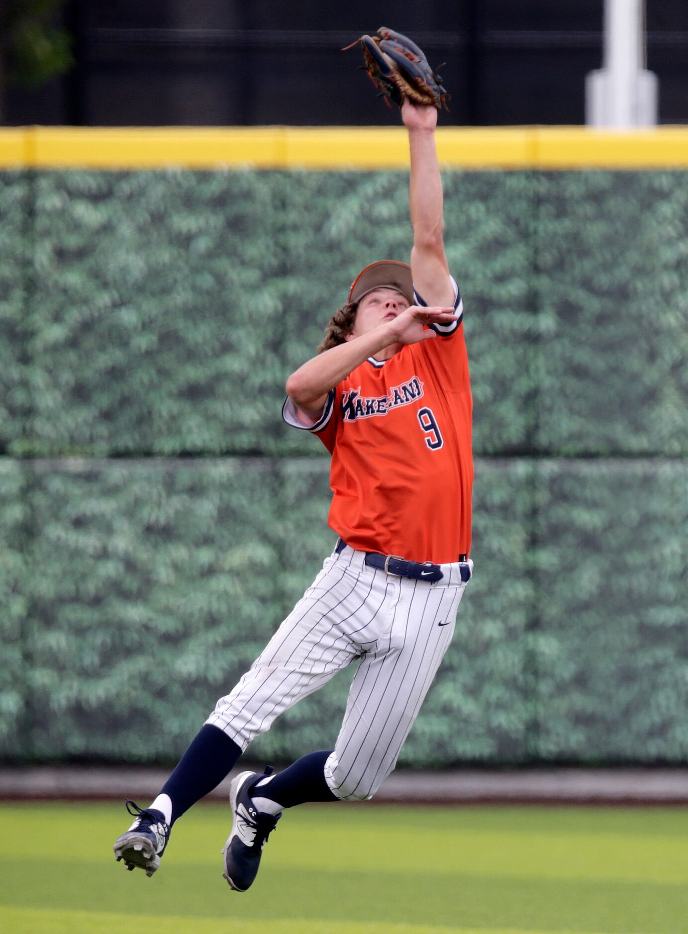 Wakeland High School second baseman Dylan Snead (9) makes a leaping catch to end the second...