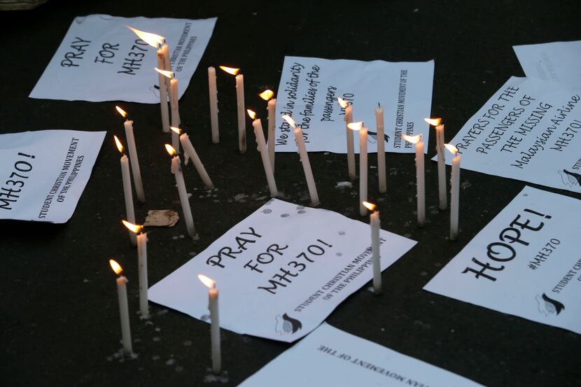 Candles are lit next to messages as students express hope and solidarity for the passengers...