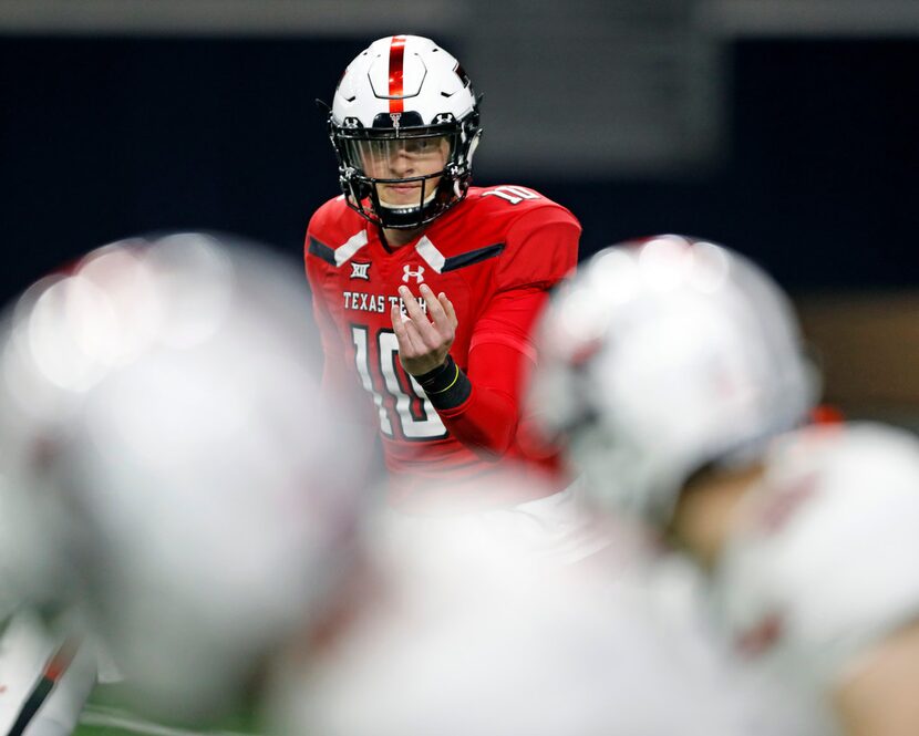 Texas Tech's Alan Bowman (10) calls over Brandt Schilling (80) during an NCAA college...